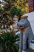 Luang Prabang, Laos. Wat Aham, statues guarding the front doors of the sim. 